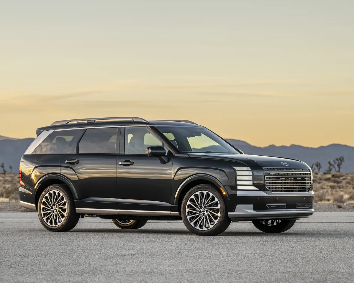 Hyundai Palisade 2026 noir vu de trois quarts avant au crépuscule, montagnes du désert à l'horizon.