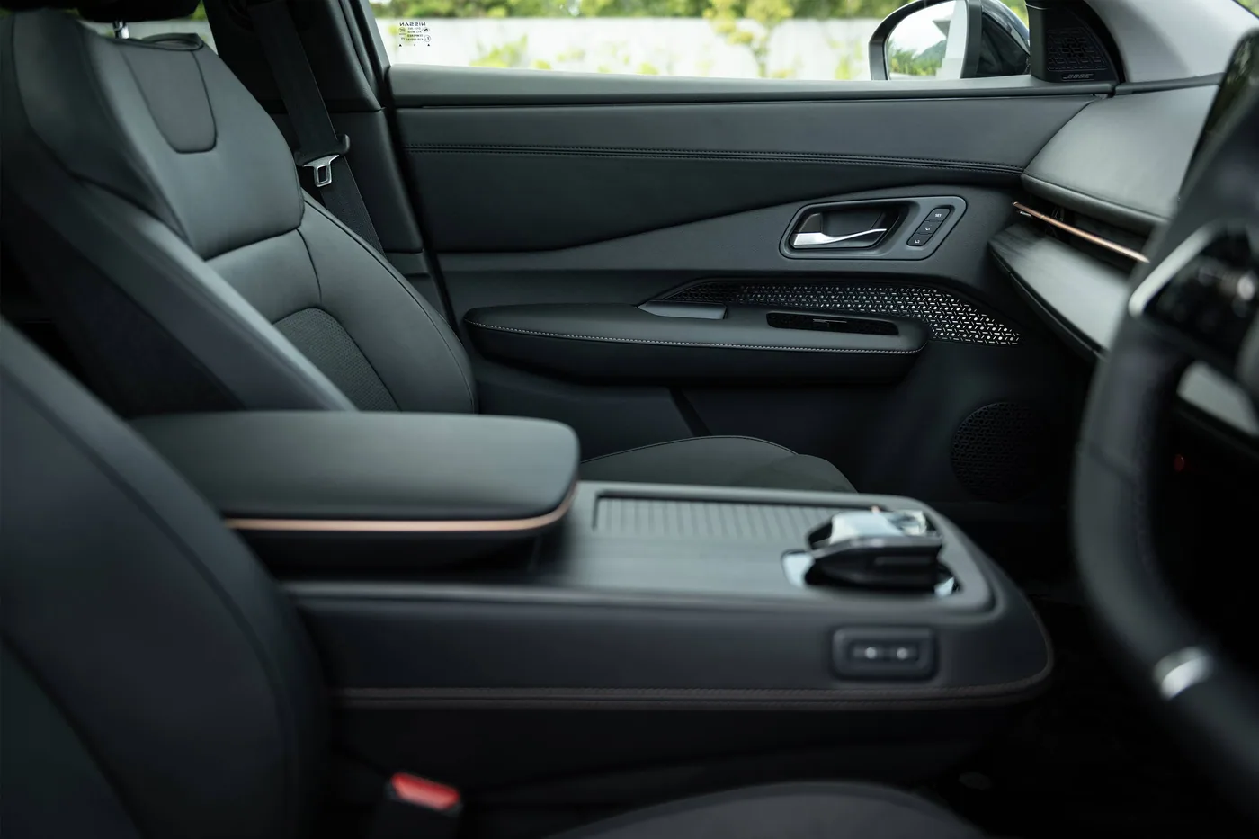 Console centrale et accoudoir en cuir noir de la Nissan Ariya, avec garniture de porte perforée
