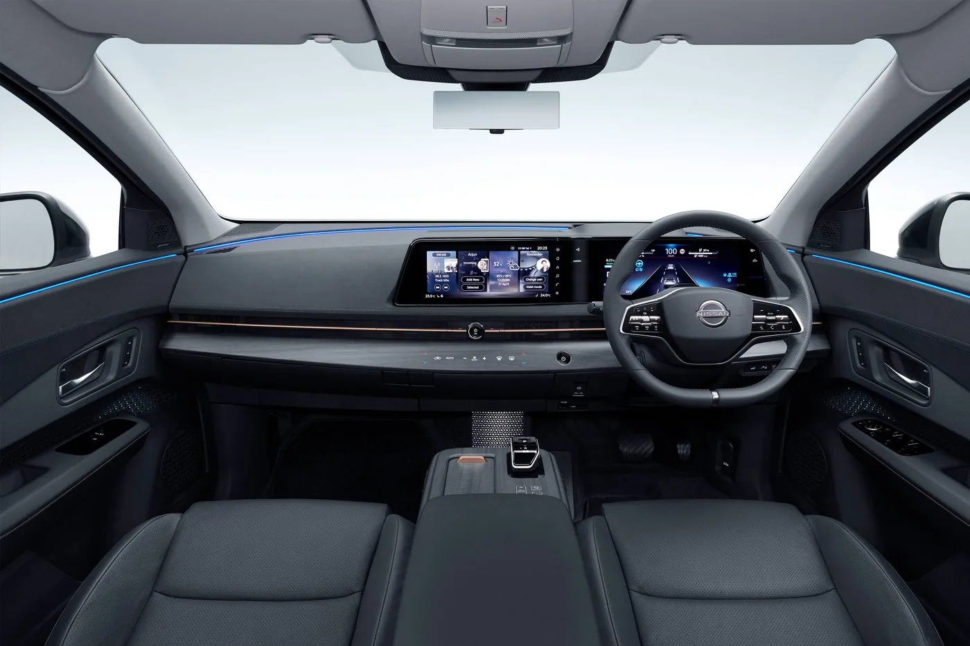 Habitacle de la Nissan Ariya vu de l'arrière : écrans jumelés, volant, console centrale et éclairage bleu