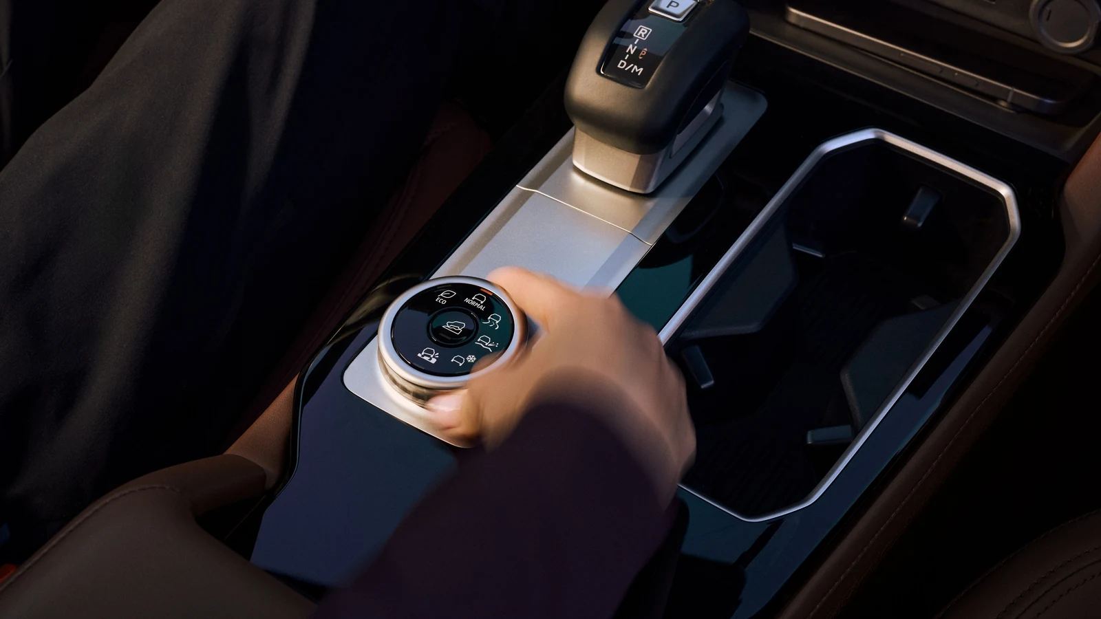Main d'un conducteur sur la molette du sélecteur de mode de conduite, console centrale d'un Mitsubishi Outlander