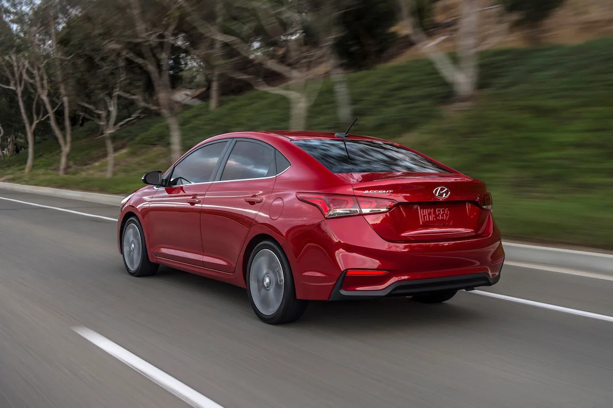 Hyundai Accent 2020 rouge en mouvement sur une route, vue de trois quarts arrière