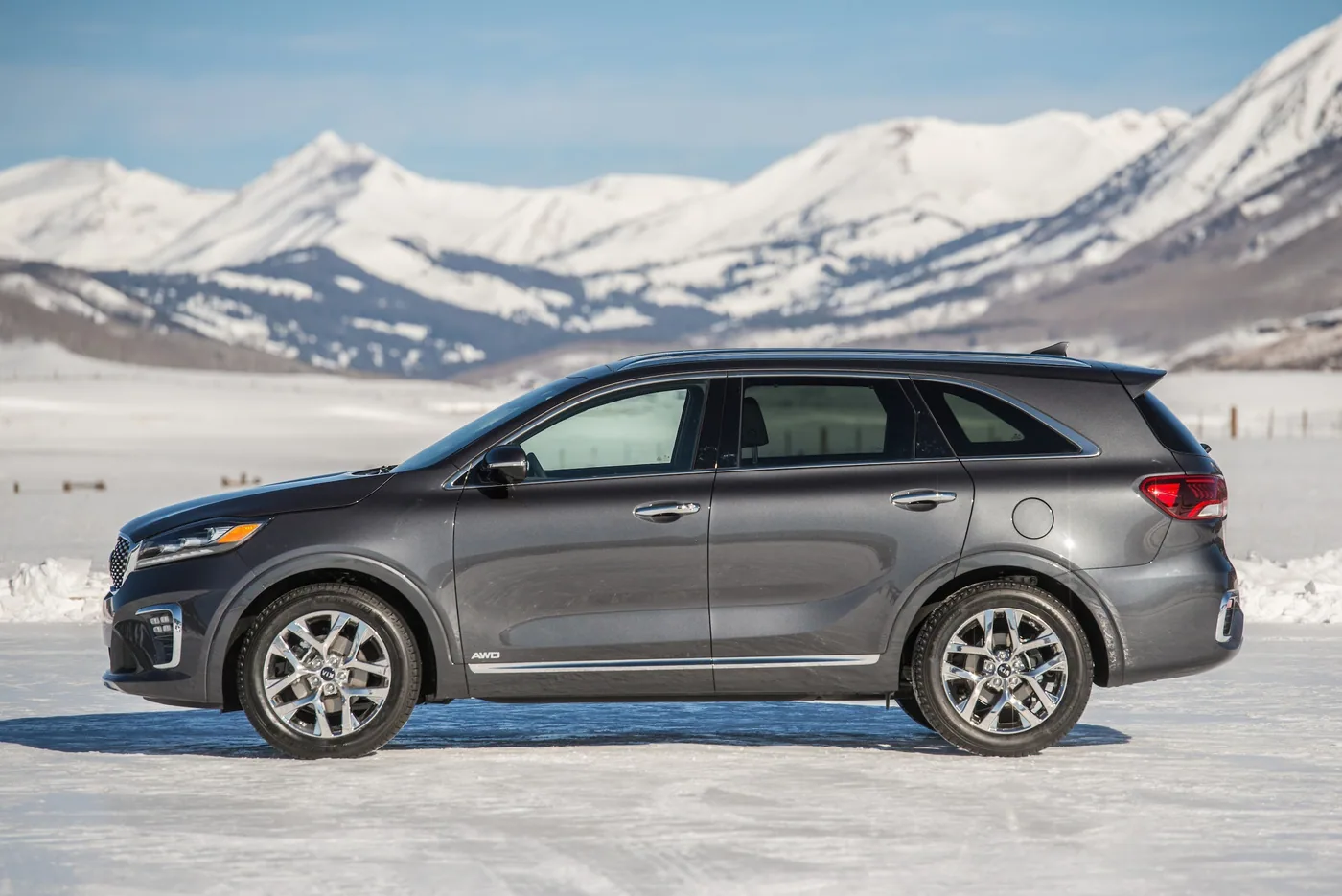 Kia Sorento 2020 gris foncé à traction intégrale, vue de profil, sur la neige devant des montagnes enneigées