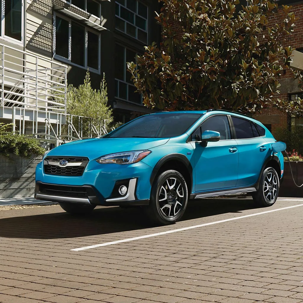 Subaru Crosstrek PHEV 2023 bleu turquoise branché à une borne de recharge en ville