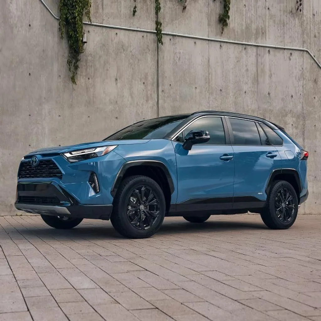 Toyota RAV4 2023 bleu aux jantes noires garé devant un mur de béton