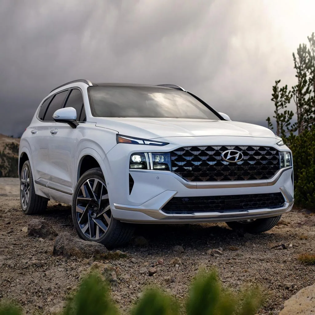 Hyundai Santa Fe 2023 blanc vu de trois quarts avant sur un terrain rocailleux