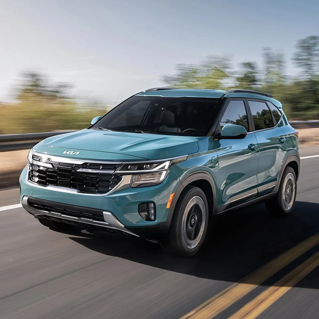 Kia Seltos 2024 turquoise en mouvement sur une route, vue de trois quarts avant