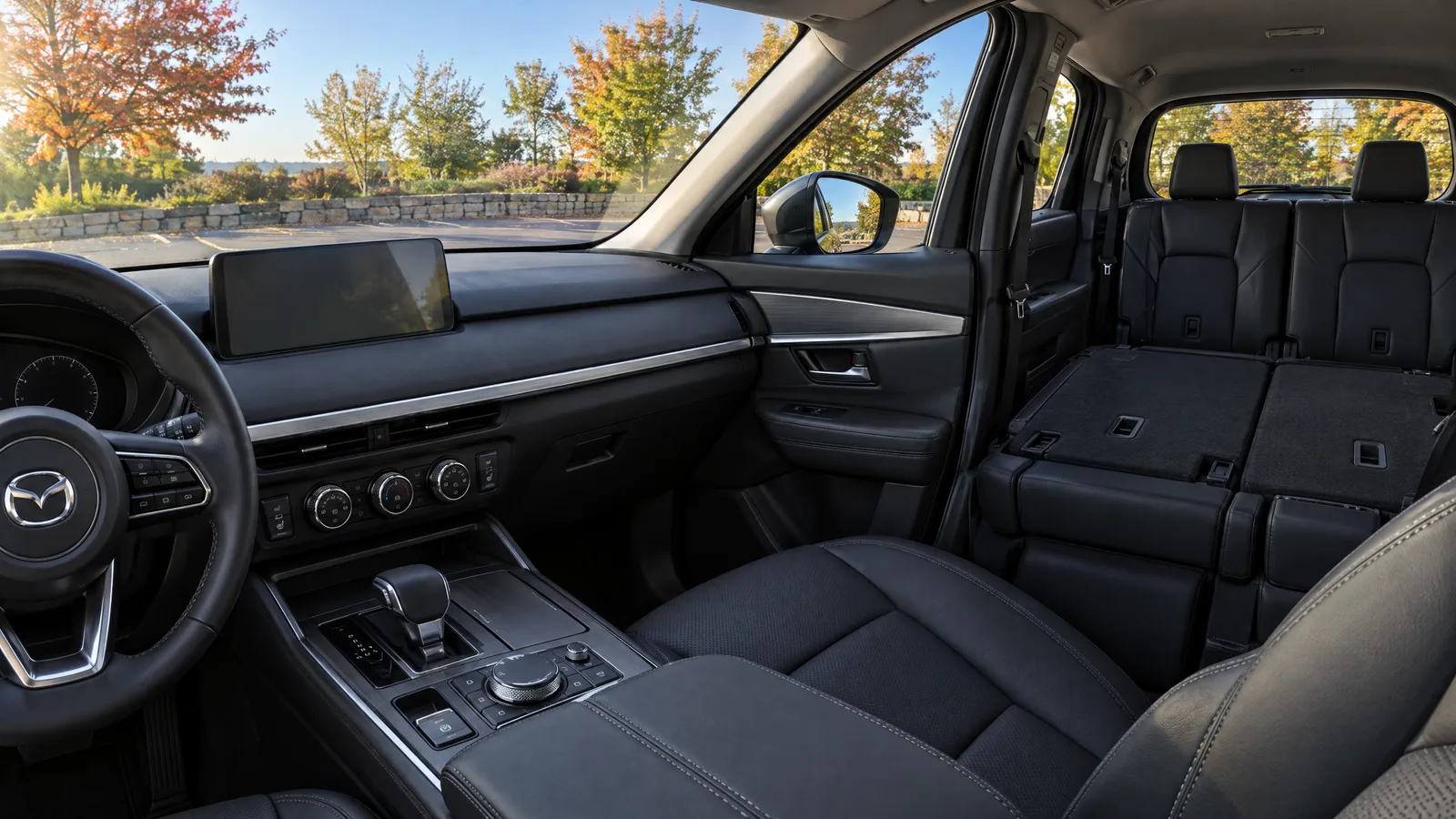 Habitacle d'un Mazda CX-90 2026 vu depuis le siège passager, écran central en veille, sellerie de cuir noir, troisième rangée visible à l'arrière