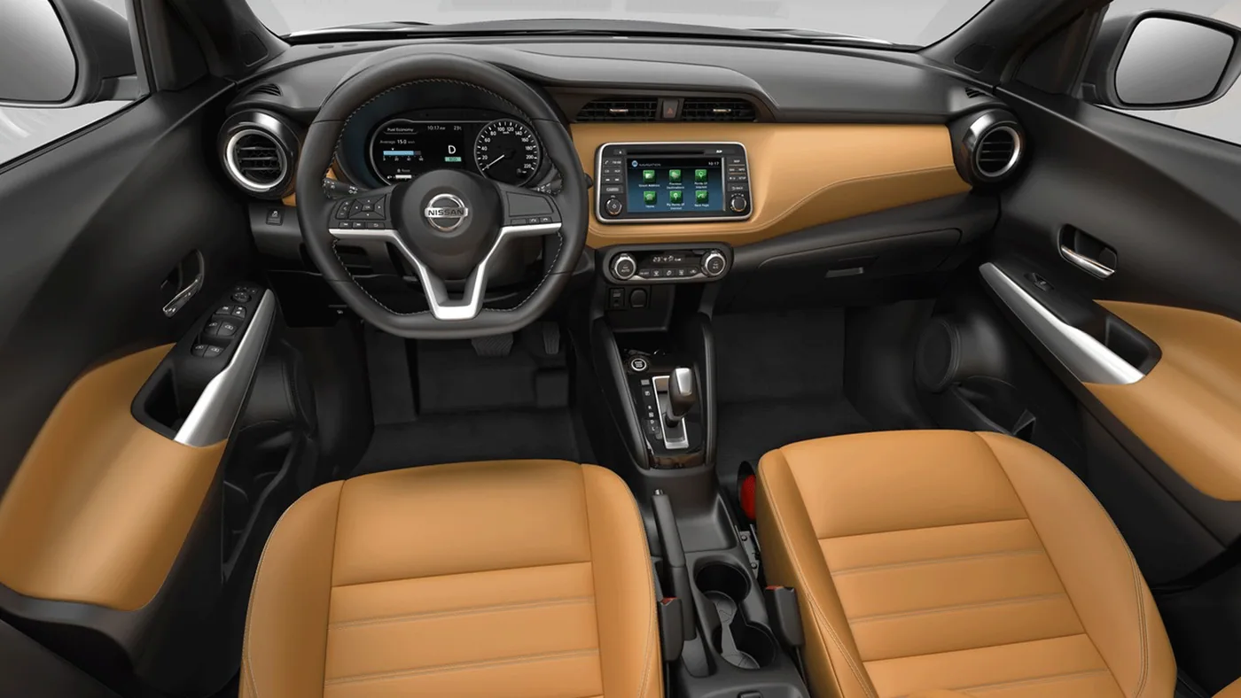 Habitacle du Nissan Kicks vu de dessus : planche de bord noire et orangée, volant, écran et sièges avant en cuir brun orangé