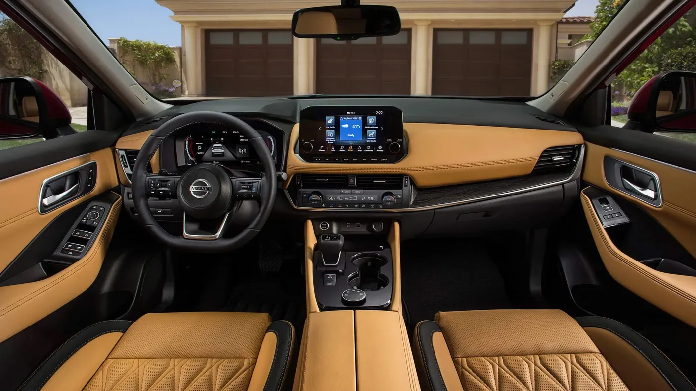 Habitacle du Nissan Rogue 2023 avec sellerie de cuir caramel, volant Nissan et écran central