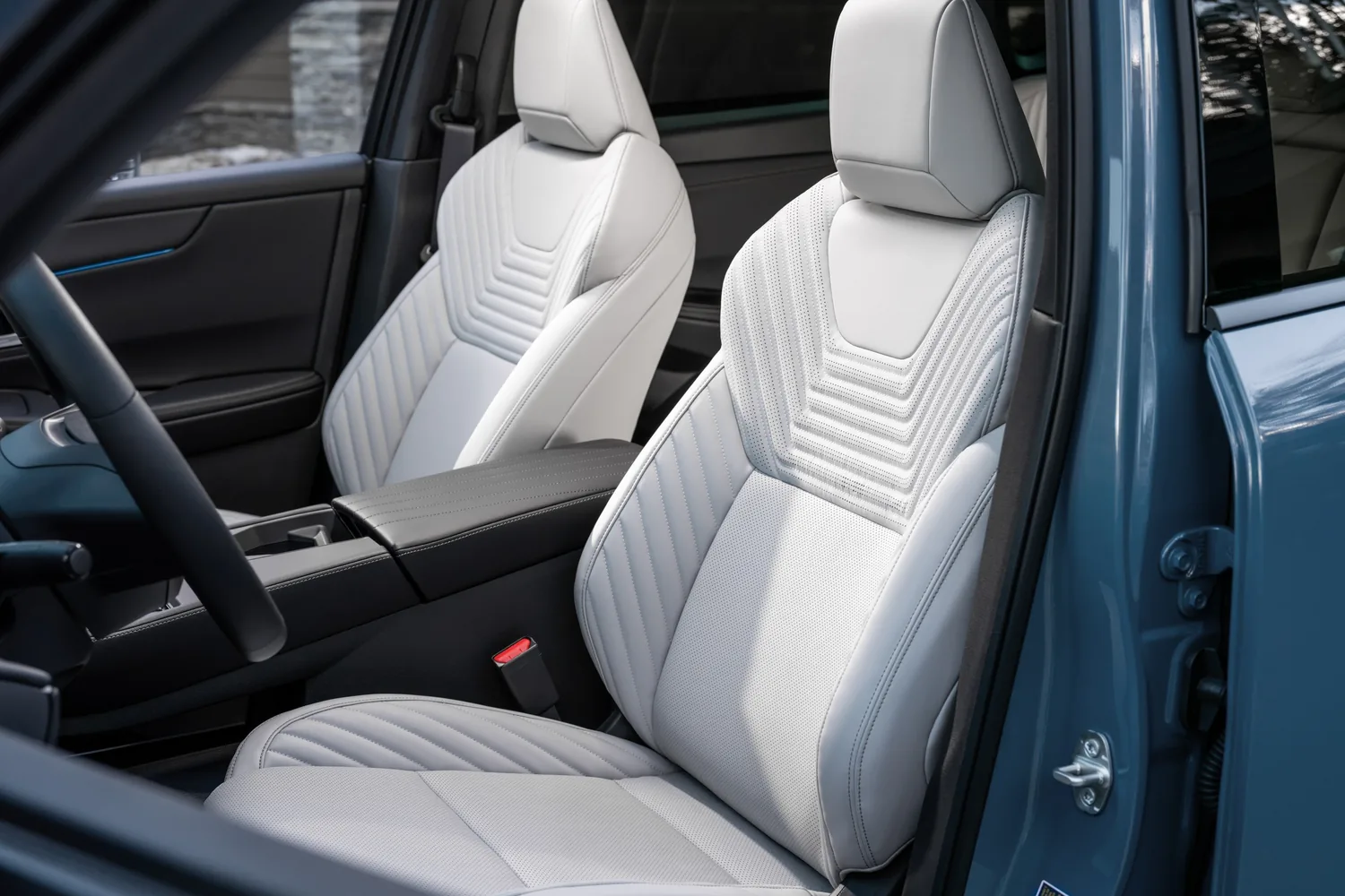 Sièges avant en cuir gris pâle à motif matelassé d'un Nissan Rogue hybride 2027, portière ouverte