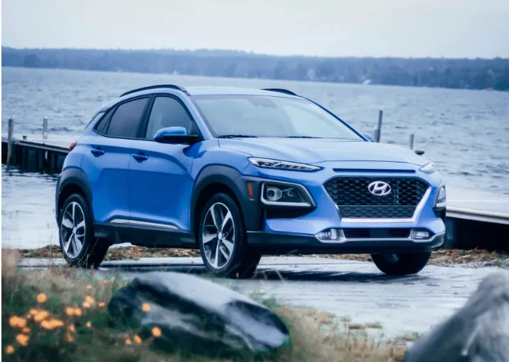 Hyundai Kona bleu, vue de trois quarts avant, stationné près d'un quai au bord d'un lac