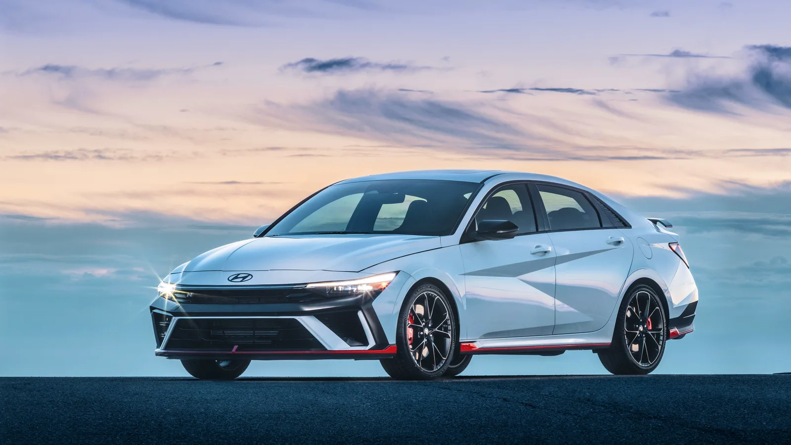Hyundai Elantra N 2026 bleu pâle, entière, vue de trois quarts avant au crépuscule.
