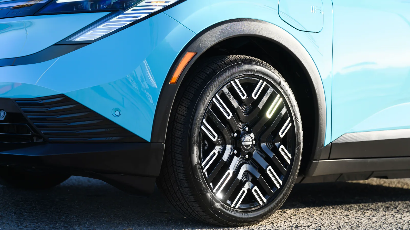 Détail de la roue avant d’une Nissan LEAF 2026 turquoise, avec l’emblème Nissan au centre de la jante.