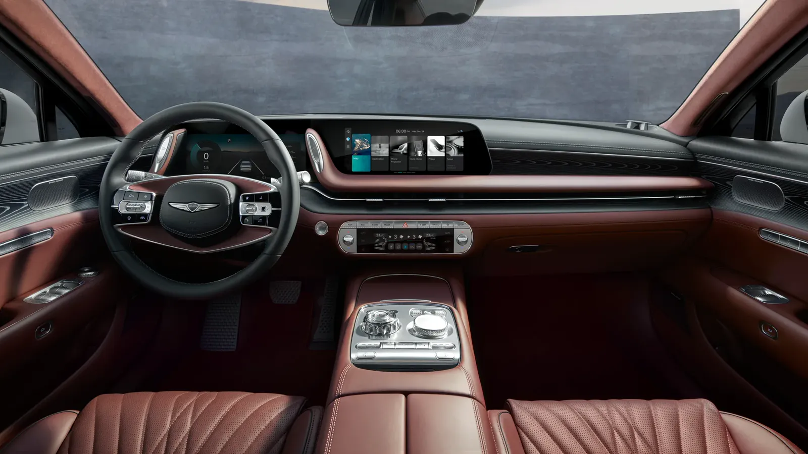 Planche de bord d’une Genesis G90 vue depuis la banquette arrière, sellerie de cuir bordeaux matelassée et écrans allumés.