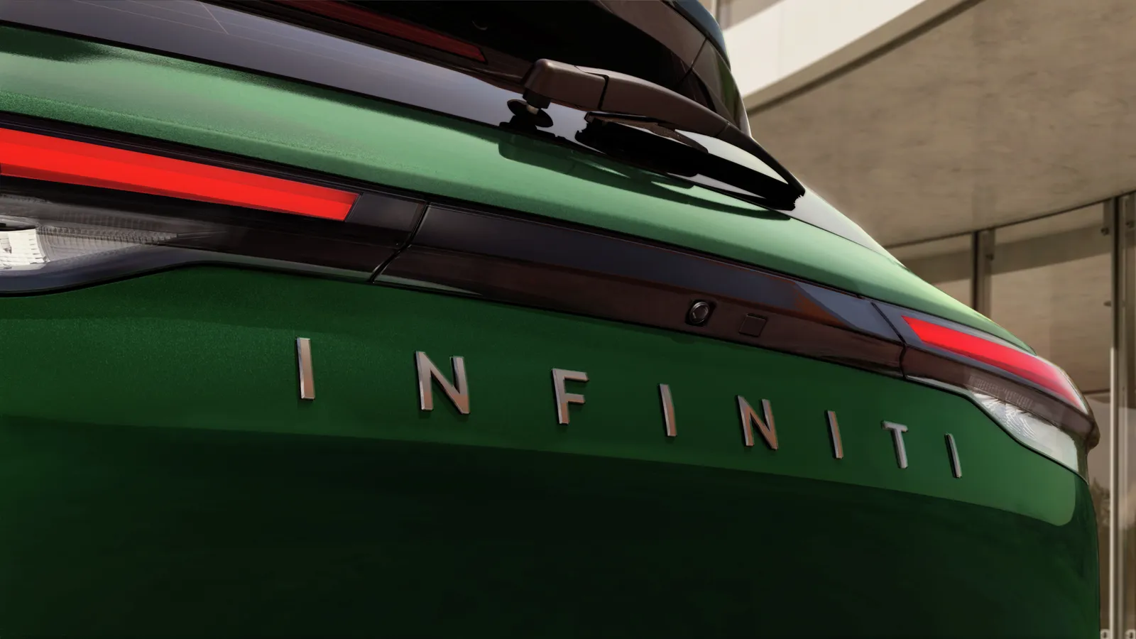 Gros plan sur le feu arrière et le mot-symbole INFINITI d’un QX60 2027 vert foncé.