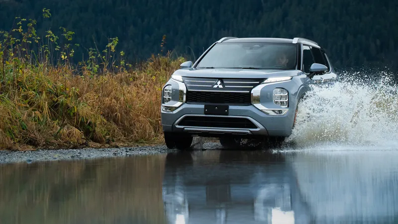 Mitsubishi Outlander PHEV qui traverse une flaque au bord d’un lac