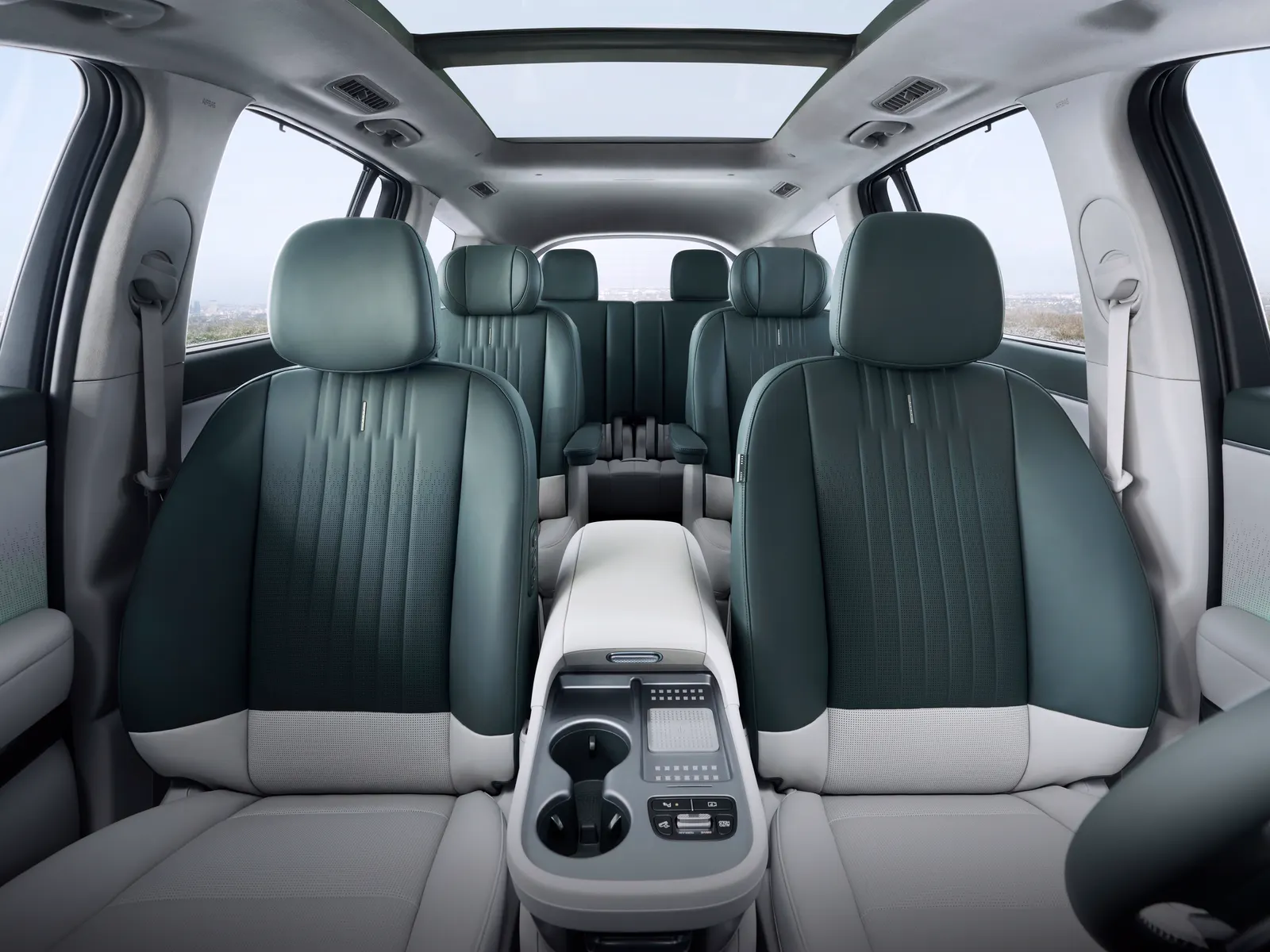 Habitacle d'un Hyundai IONIQ 9 vu depuis l'avant : fauteuils capitaine en deuxième rangée, banquette de troisième rangée et toit vitré.