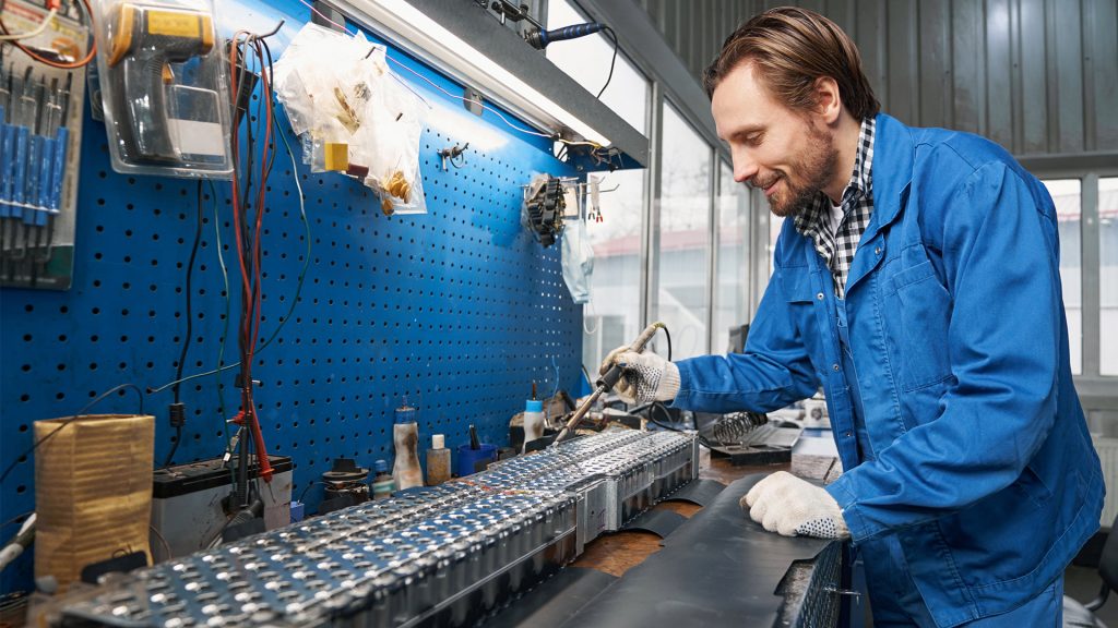 Smiling man inspecting car battery 2